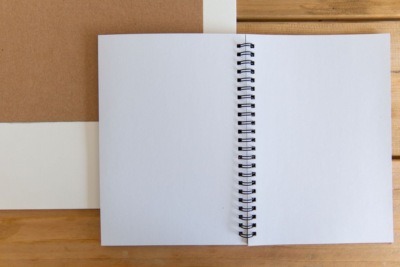 Carnet à spirales ouvert sur un bureau en bois clair.
